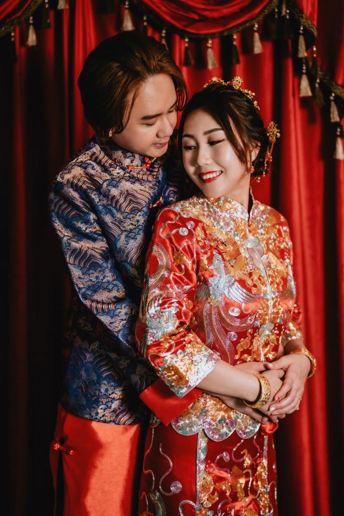 A couple dressed in traditional Chinese clothing poses together for a photograph, showcasing their cultural attire.