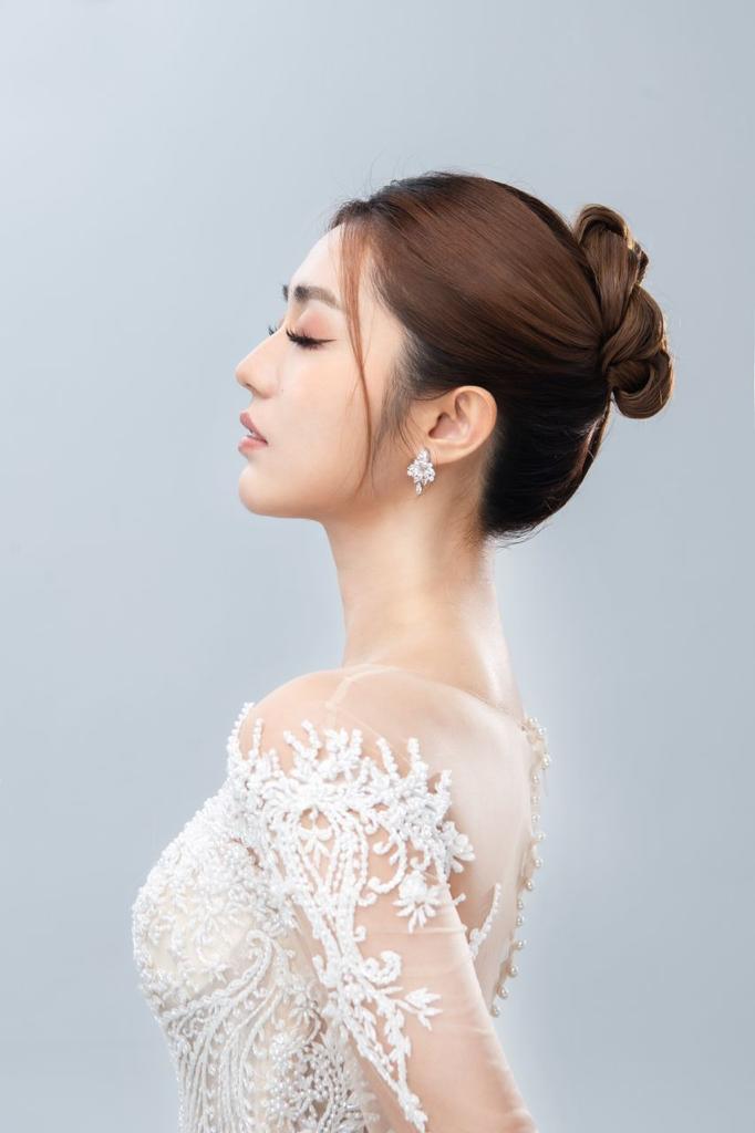 Beautiful Asian woman wearing an elegant white wedding dress, radiating joy and grace on her special day.
