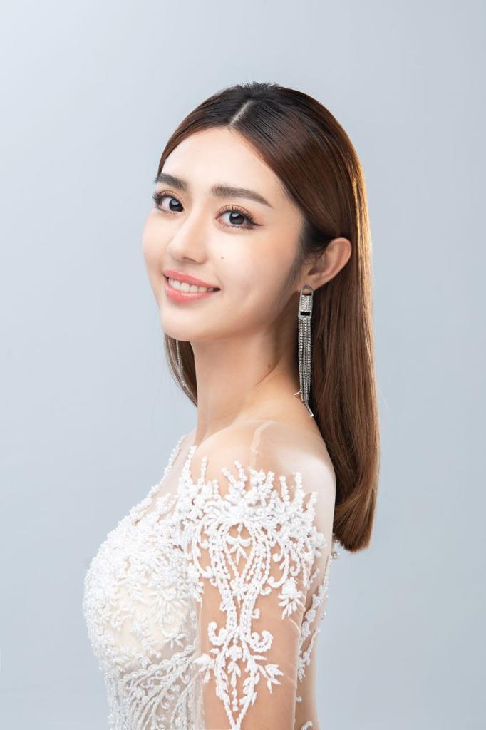 Smiling bride with sleek straight hair, dramatic tassel earrings and a beaded illusion gown