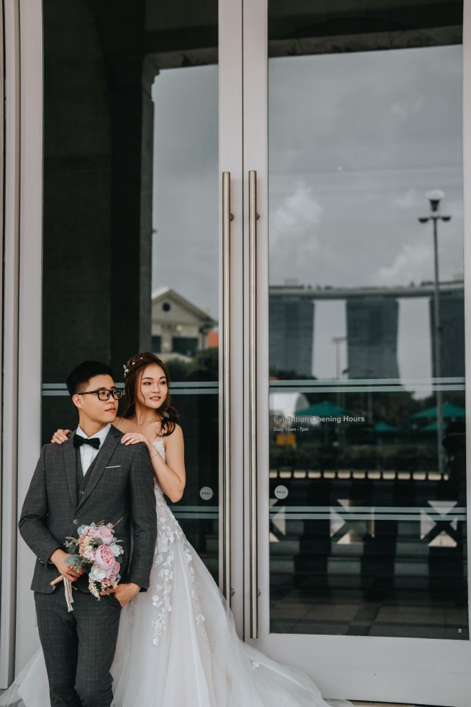 Pre-wedding photo with Marina Bay Sands reflected in glass doors