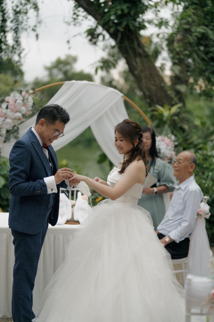 Outdoor ROM ceremony with ring exchange in a garden setting