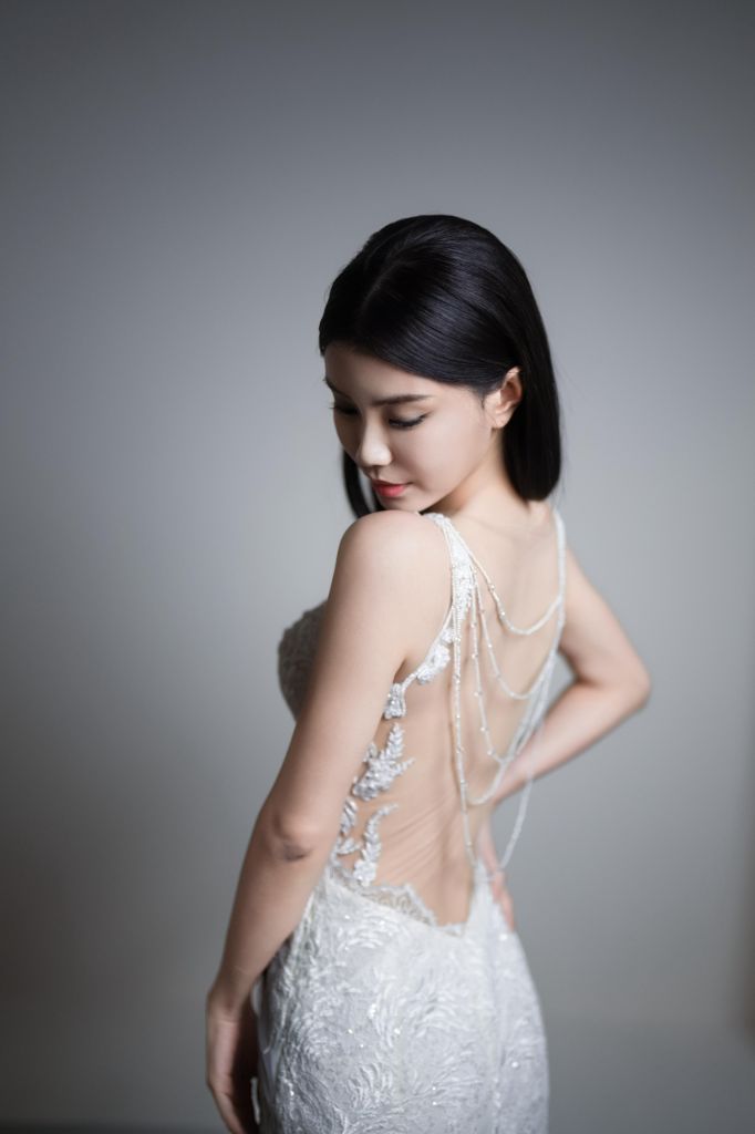 Bridal portrait showcasing the sheer beaded back of a lace gown
