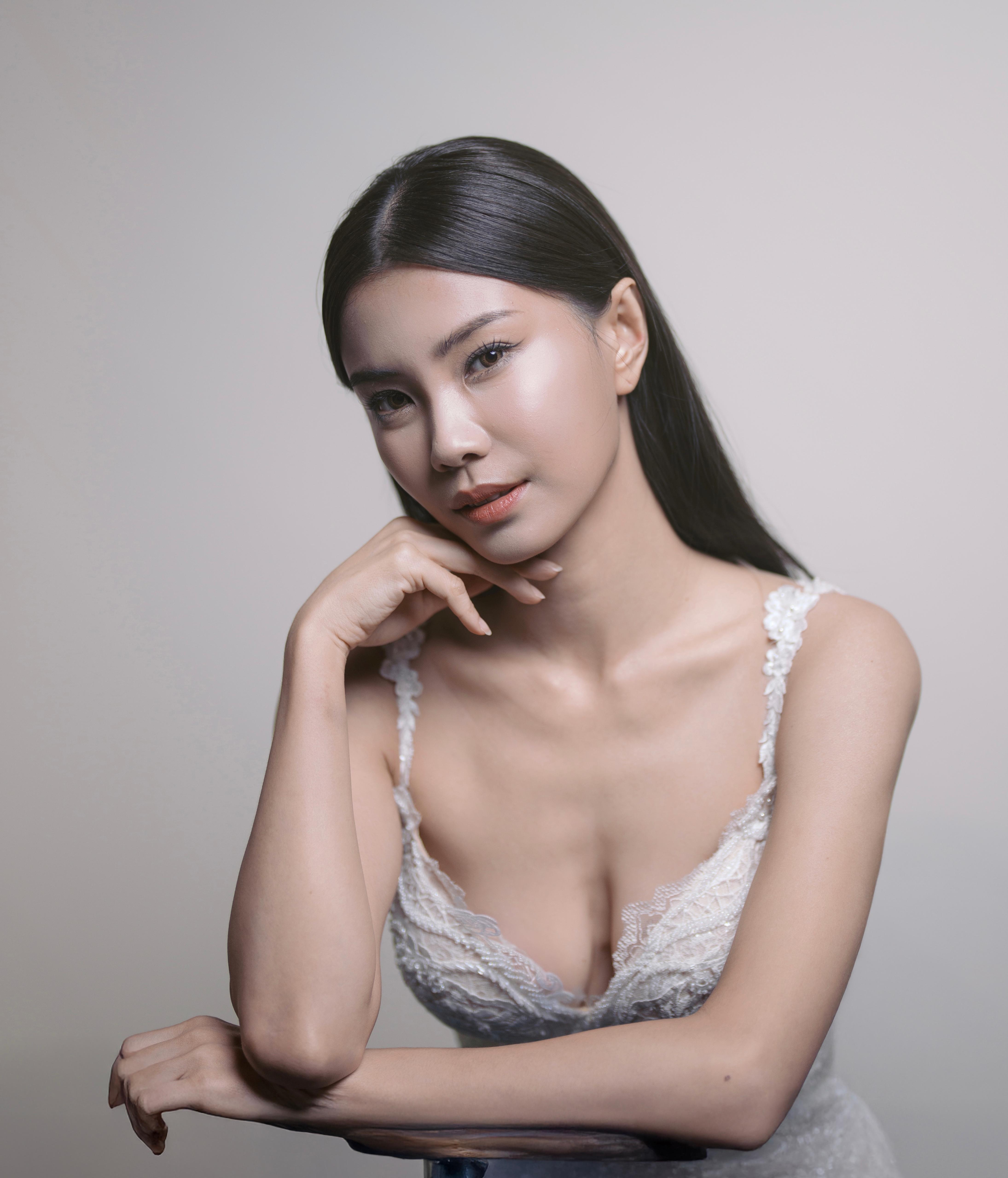 Bridal portrait with luminous skin, soft coral lip and a delicate lace gown